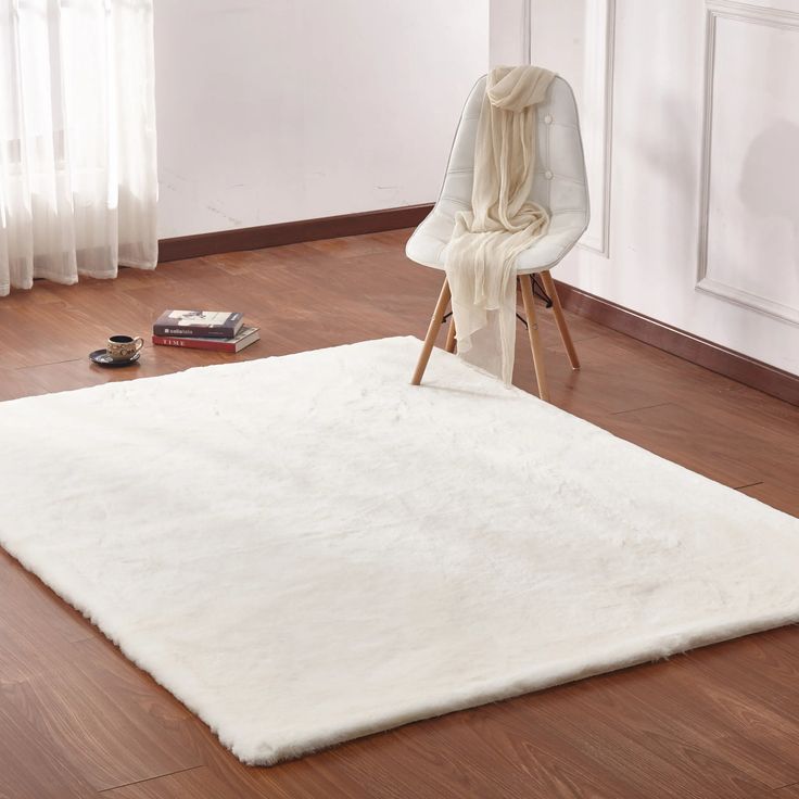 a white rug on the floor with a chair in the background