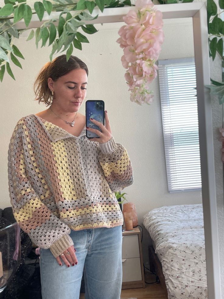 a woman standing in front of a mirror taking a selfie with her cell phone