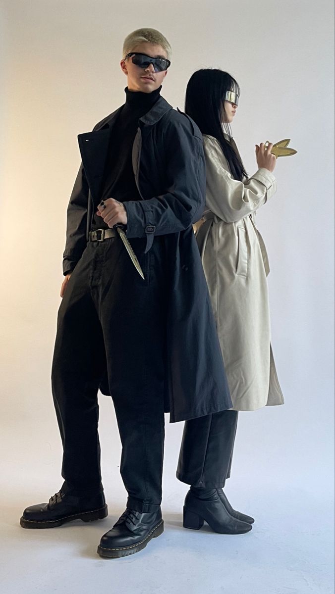 two people standing next to each other in front of a white background wearing black clothing