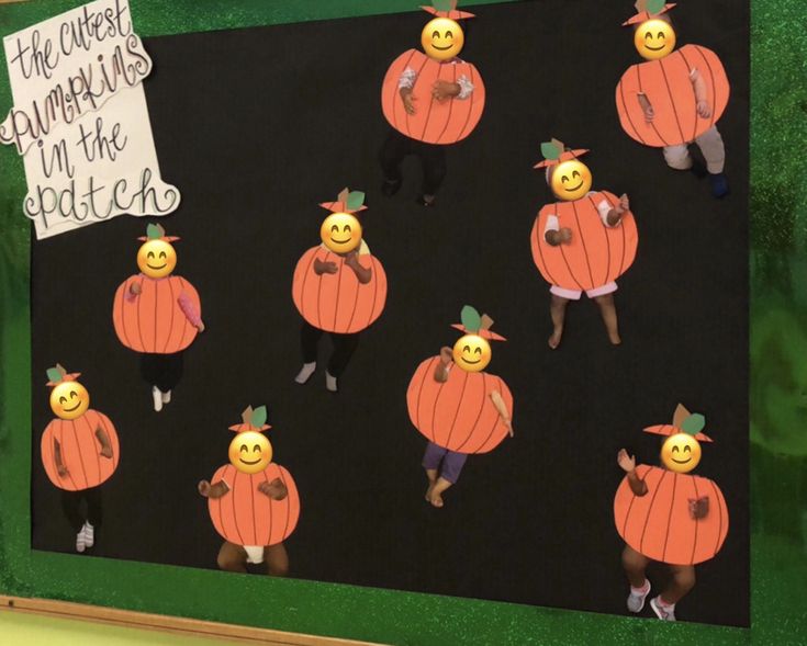 a bulletin board with lots of pumpkins on it's sides and people in the middle