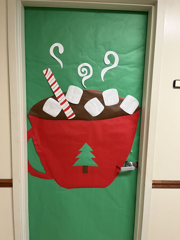 a green door decorated with a red cup filled with hot chocolate and marshmallows