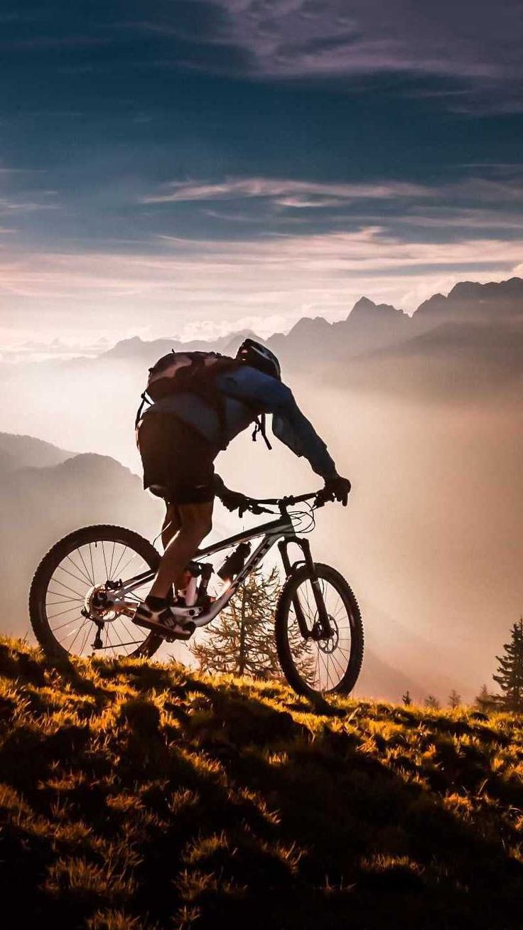 a person riding a bike on top of a hill