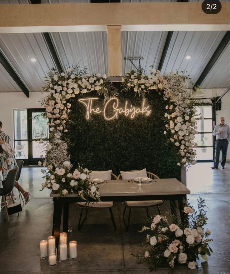 a table with flowers and candles in front of a sign that says the good place