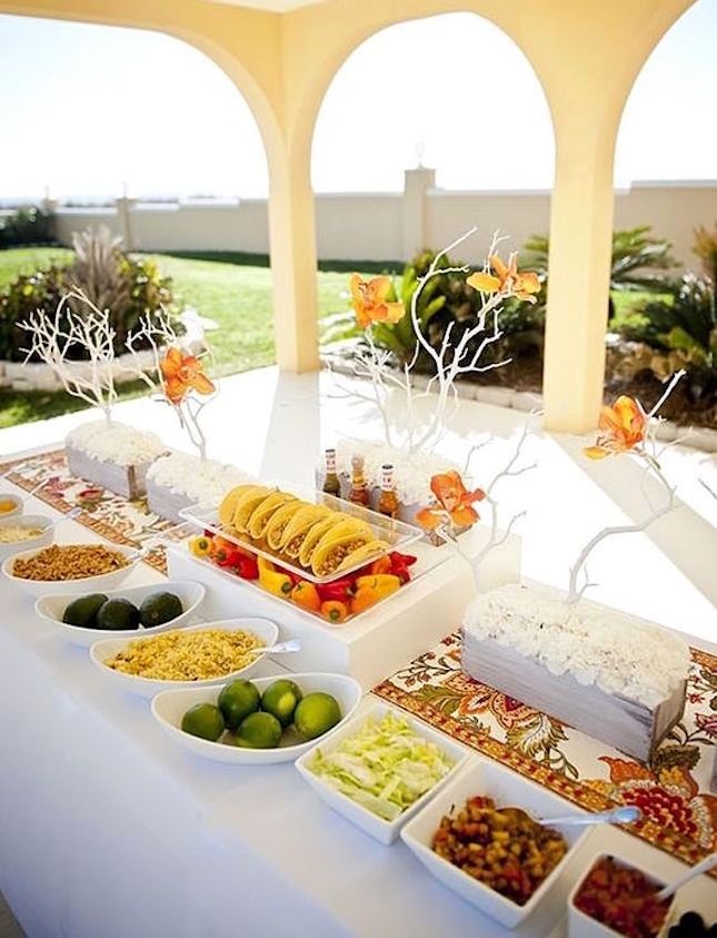 an outdoor buffet is set up with fruit and vegetables on the table for guests to enjoy