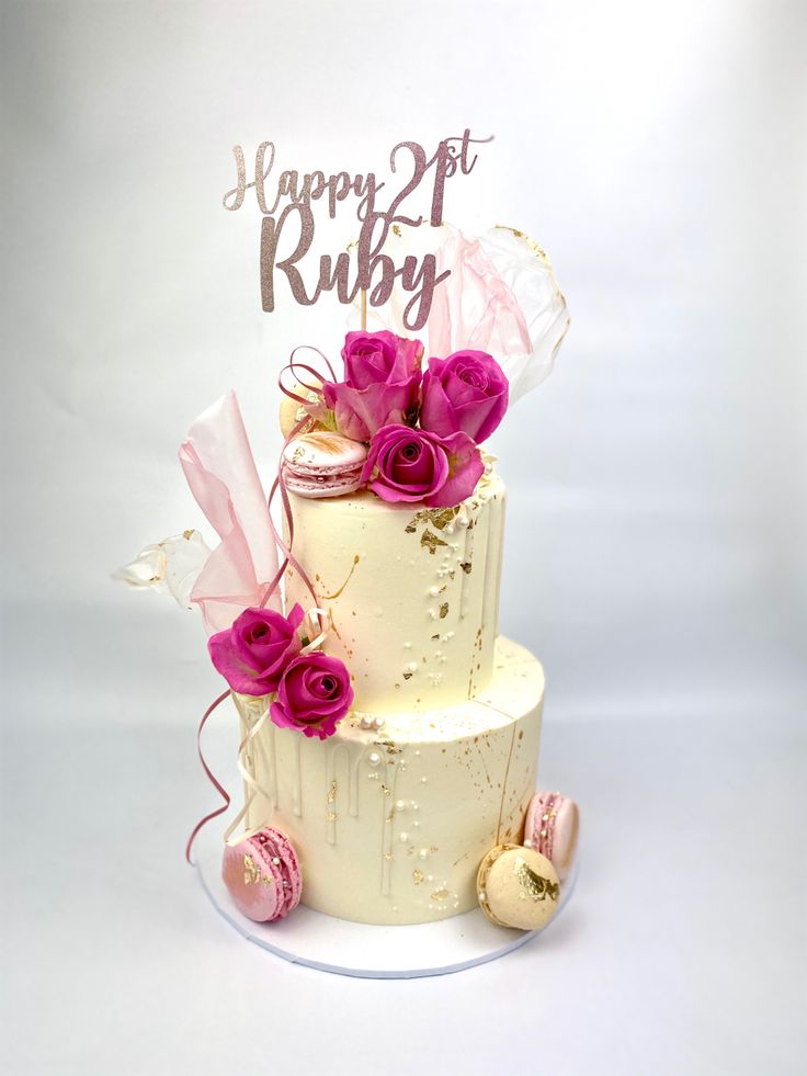 a three tiered cake with pink flowers on top and a happy 21st ruby sign