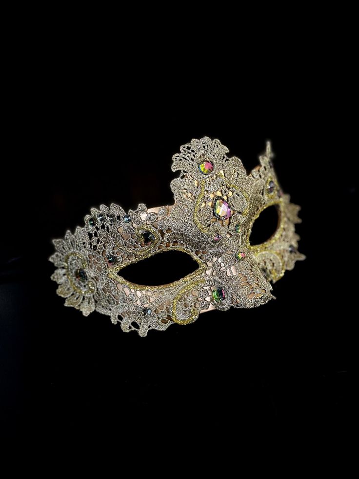 The intricate brocade lace design adds a touch of sophistication and the jewels are carefully placed to catch the light and enhance your beauty. Securely and comfortably fits every face shape so you can enjoy a perfect evening at the masquerade ball.

Age Group/Gender - Adult/Women

Size/Type - One size fits all adults

Mask Color - Gold

Mask Material - Polyresin/Fabric

Accent Material - Gems Elegant Fitted Masquerade Mask For Mardi Gras, Silver Embellished Lace For Party, Elegant Silver Eye Mask, Formal Venetian Eye Mask For Masquerade, Elegant Fitted Masquerade Mask For Costume Party, Elegant Adjustable Masquerade Mask For Mardi Gras, Silver Formal Masquerade Mask For Carnival, Venetian Style Formal Eye Masquerade Mask, Wedding Masquerade Mask With Rhinestones