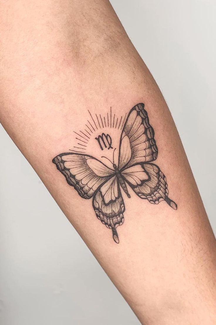 a small butterfly tattoo on the arm