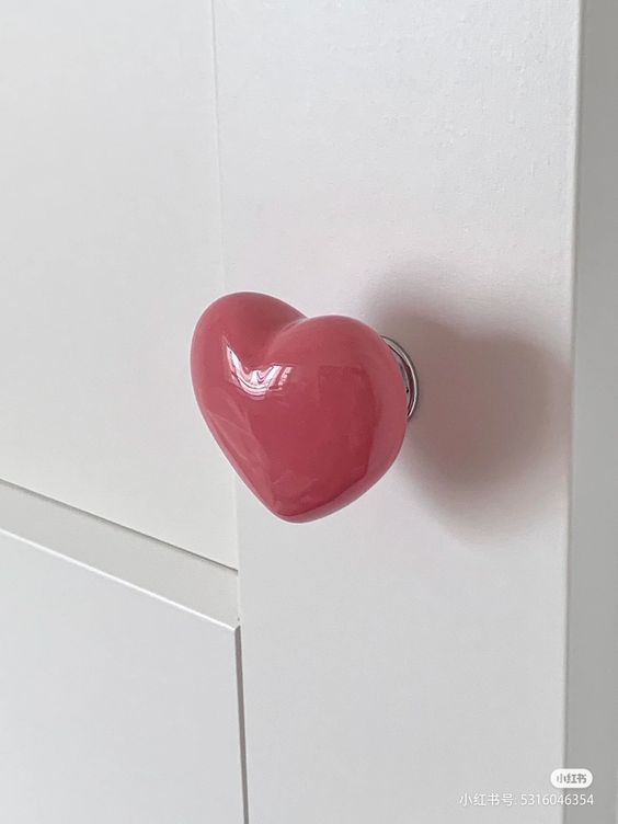 a heart shaped door handle on a white cabinet