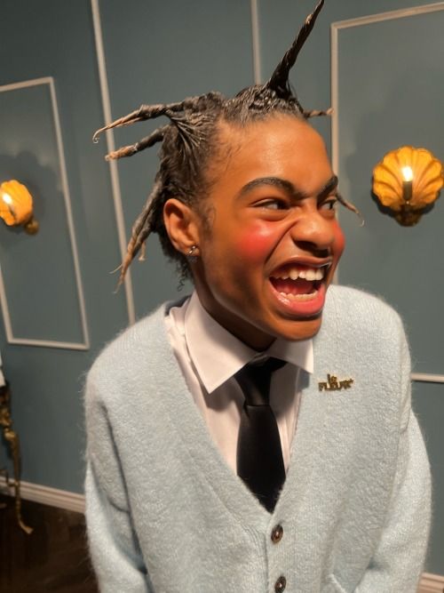 a person with dreadlocks and a tie