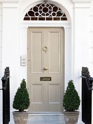 two potted plants sit in front of a door