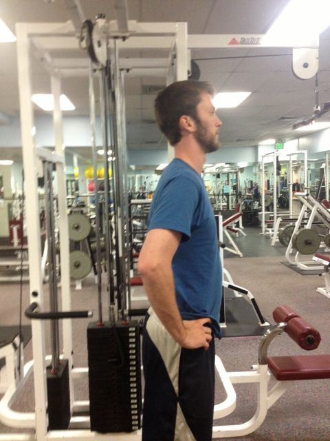 a man standing in front of a gym machine