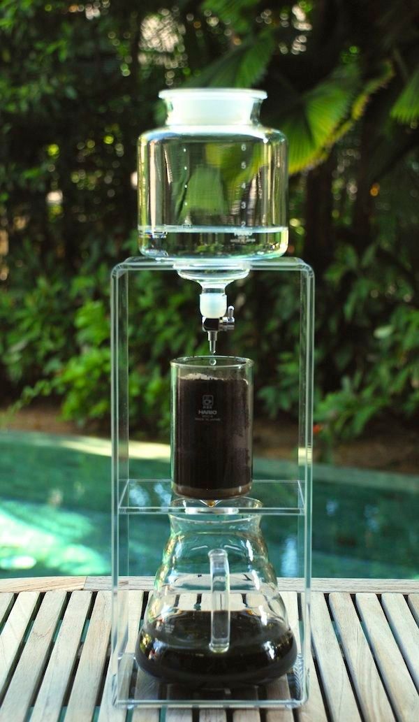 a water dispenser sitting on top of a wooden table next to a pool