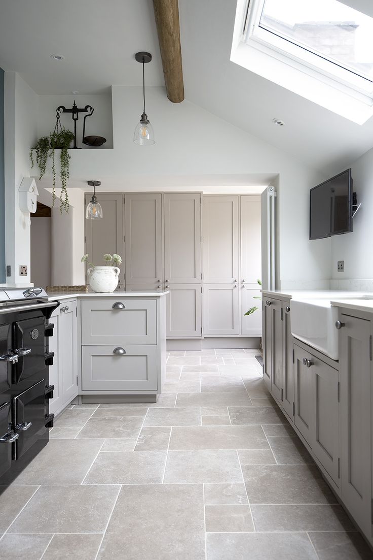 a kitchen with white cabinets and gray flooring