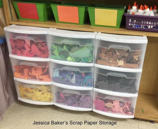 plastic bins filled with different colored paper and crafting supplies on a shelf in a classroom