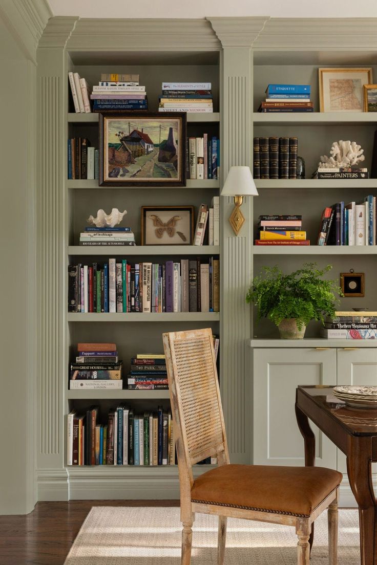 a chair sitting in front of a book shelf filled with books