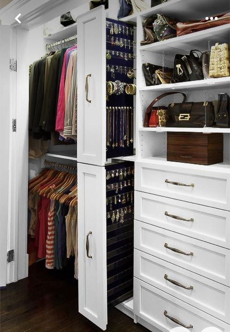 an organized closet with white cabinets and drawers