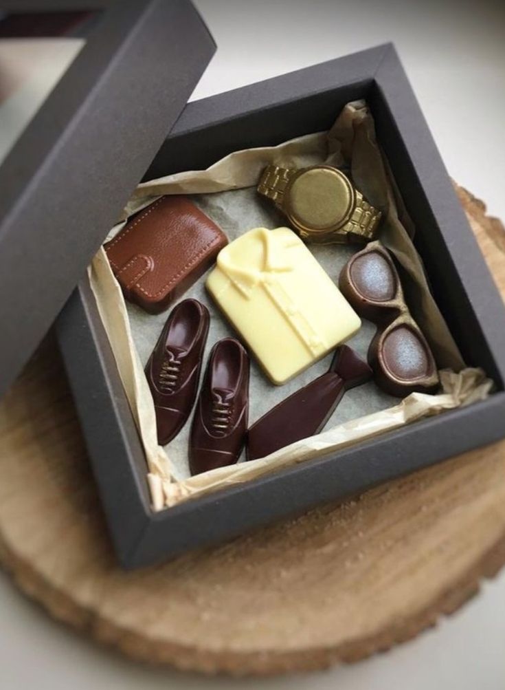 an open box with some shoes and other items in it on top of a wooden table