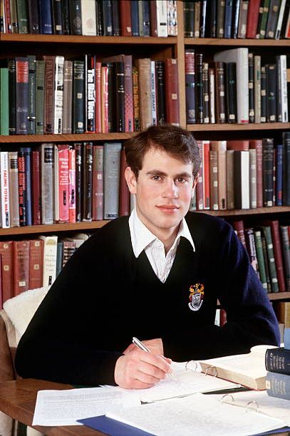 a man sitting at a desk in front of a bookshelf filled with books