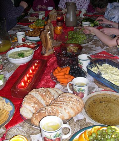 a table full of food with people sitting at it