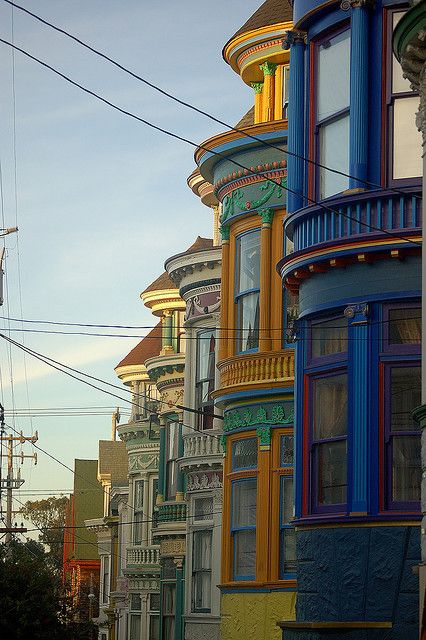 a row of multicolored houses on the side of a street in san francisco