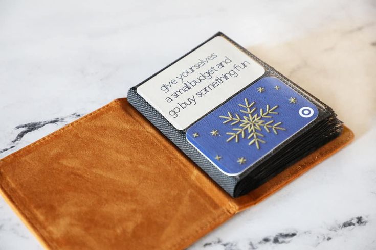 a brown wallet with a blue and gold snowflake card holder sitting on top of it