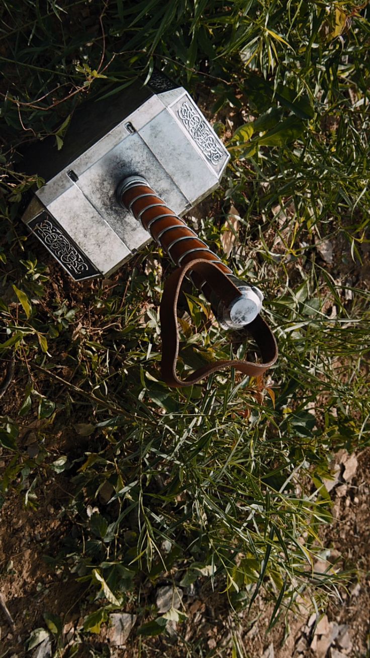 an old rusted parking meter sitting in the middle of some grass and weeds,