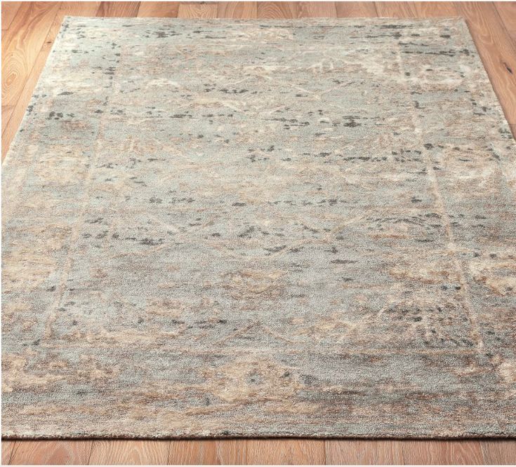 an area rug on the floor with wooden floors and hard wood planks in the background