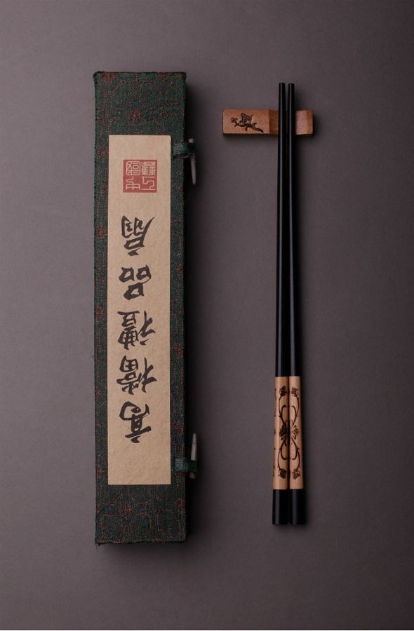 two chopsticks sitting next to each other in front of a book with writing on it