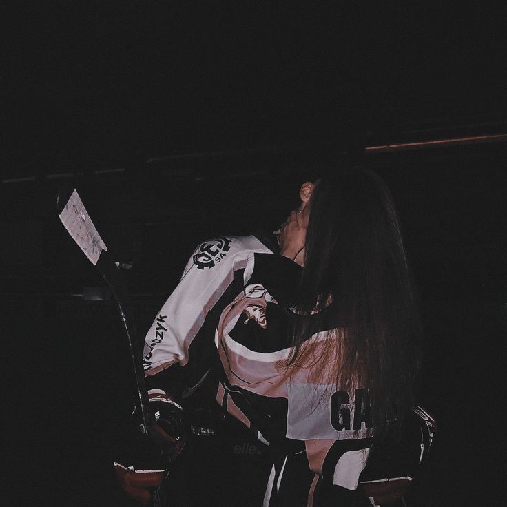 a female hockey player is holding her stick