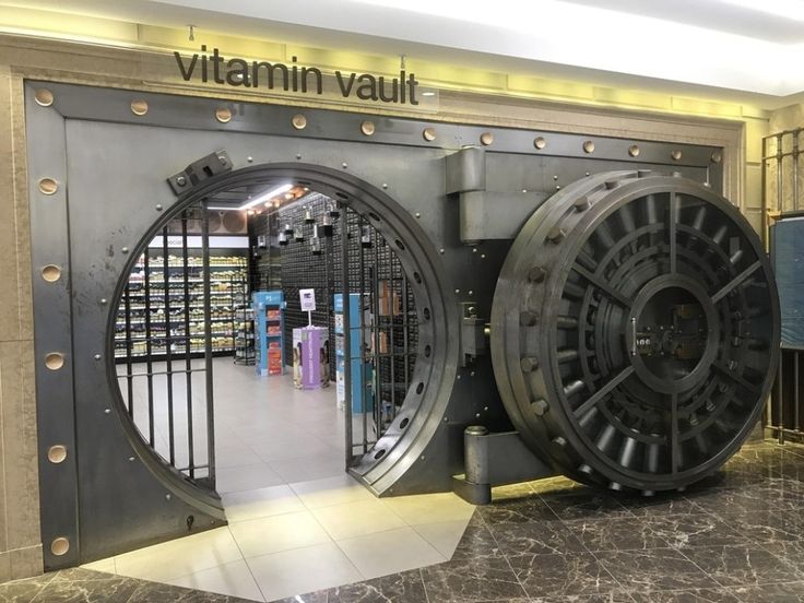 a large metal object sitting in the middle of a room next to a door that says vitamin vault