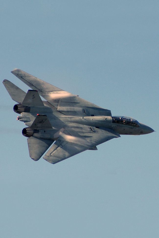 a fighter jet flying through a blue sky