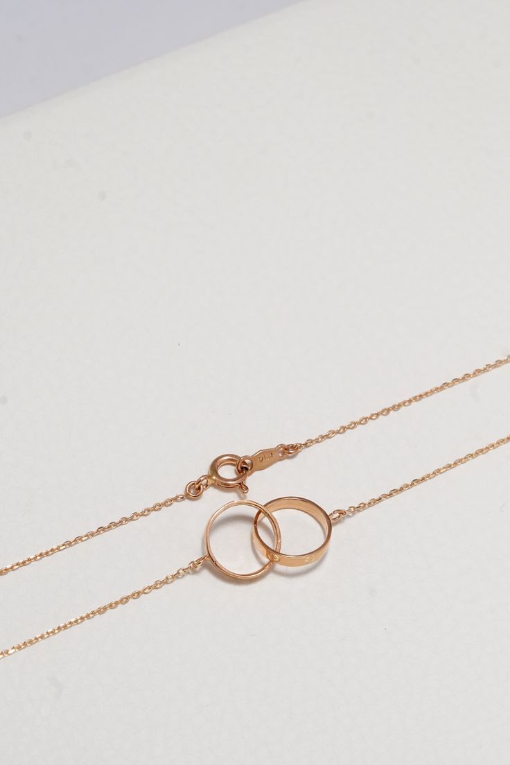 ITEM INFO This exquisite piece, featuring a pair of interlocked rings on a delicate round chain, symbolizes connection and harmony in a chic, minimalist design. Perfect for those who appreciate the beauty of simplicity and the warmth of rose gold, here's why this necklace is a must-have addition to your collection: Symbolic Elegance: The interlocked rings represent the unbreakable bonds of love and friendship, making this necklace not just a piece of jewelry, but a meaningful symbol. Premium Quality: Crafted from 14K solid rose gold, this necklace boasts durability and a timeless luster that elevates any outfit. Delicate Design: The sleek round chain, measuring 16 inches, ensures the double rings charm sits gracefully at the base of the neck, perfect for both everyday wear and special occa Modern Rose Gold Open Circle Jewelry, Elegant Rolo Chain Jewelry For Anniversary, Round Cable Chain Wedding Jewelry, Minimalist Wedding Jewelry With Spring Ring Clasp, Classic Rose Gold Circle Jewelry, Minimalist Rose Gold Open Circle Jewelry, Rose Gold Oval Link Wedding Jewelry, Minimalist Rose Gold Oval Link Jewelry, Minimalist Rose Gold Link Jewelry