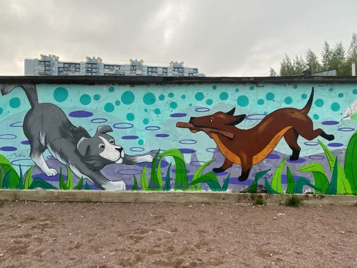 a dog and cat mural painted on the side of a building