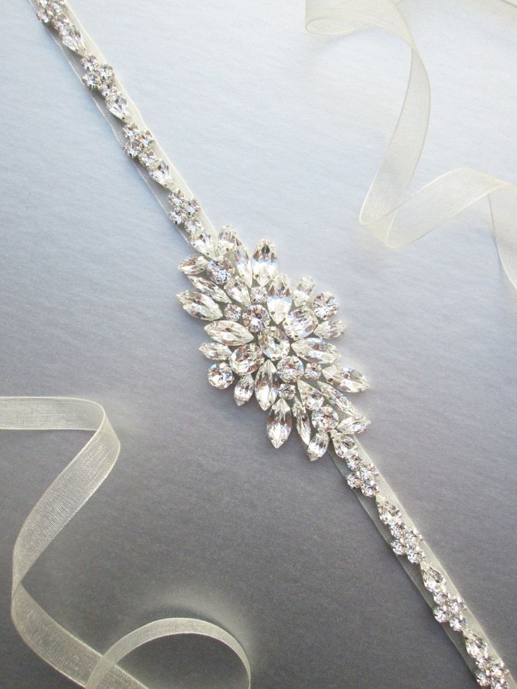 "This sparkly skinny bridal belt is made with top quality Swarovski crystals beaded on 3/8\" wide organza ribbon. The crystal part of the belt measures 24\" and 1 3/4\" wide in the center. The entire sash measures 150\" long. Available in gold or silver finish. It can be made with your choice of organza, satin or grosgrain ribbon." Party Crystal Bridal Accessories With Sashes, Formal Adjustable Bridal Belt With Sashes, Formal Bridal Belt With Crystal Sashes, Formal Crystal Bridal Belt With Sashes, Glamorous Wedding Bridal Belt With Crystals, Crystal Bridal Belt With Sashes For Party, Adjustable Bridal Belt With Sashes For Bridesmaid, Adjustable Bridesmaid Bridal Belt With Sashes, Adjustable Bridal Belt With Sashes For Party