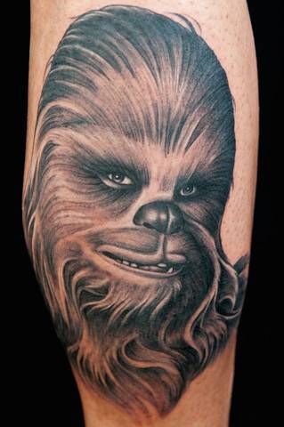 a tattoo on the leg of a man with a star wars character in his face