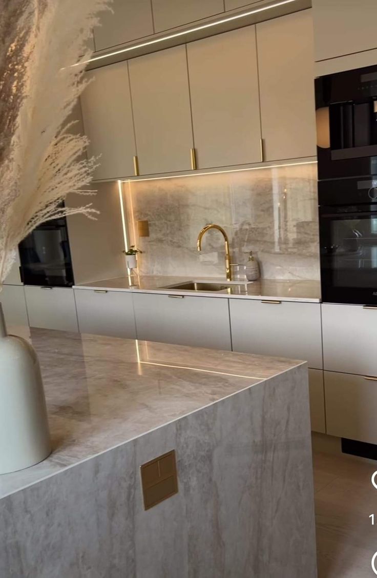 a modern kitchen with marble counter tops and stainless steel appliances in the backround