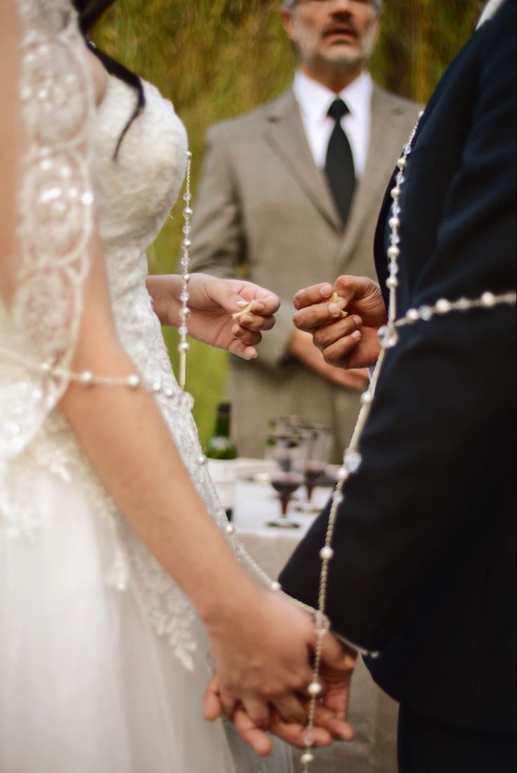 two people holding hands during a wedding ceremony