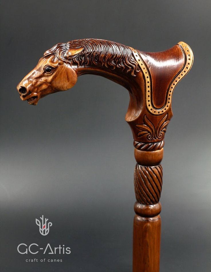 a carved wooden horse head on top of a wooden pole with an intricate carving pattern