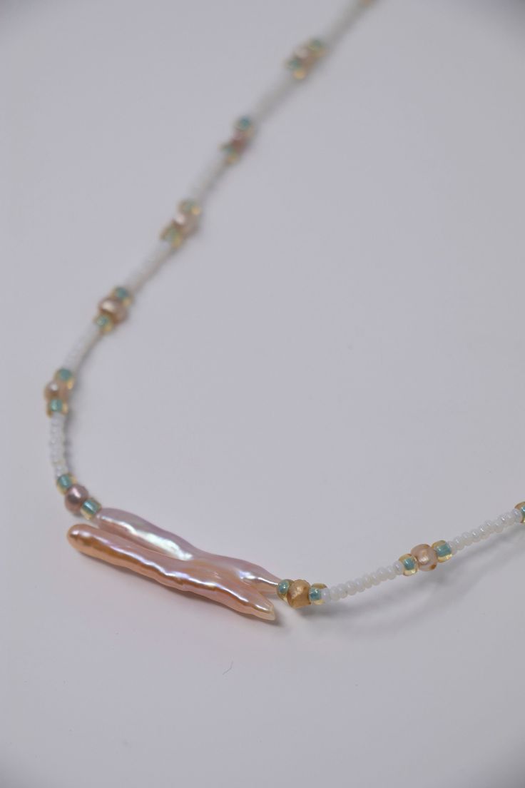 This original ocean themed necklace features a delicate pink biwa pearl on a hand beaded necklace. Biwa pearls are fabulous and no two are alike!  This one is hanging from a hand threaded necklace of pearls, white antique glass beads, and iridescent green glass beads.  Your purchase will come safely wrapped in tissue and ready for presentation in a sheer silk pouch and perfect for the mermaid in your life. Purchase of this (and all items) from VibrantSea will result in 100% of profits going to s Delicate Beaded Pearl Drop Necklaces, Delicate Beaded Pearl Necklace, Pearl Pendant Beaded Necklace As Gift, Single Strand Pearl Beads As Gift, Pink Pearl Jewelry With Tiny Beads, Unique Pearl Necklaces With Pearl Pendant, Adjustable White Beaded Necklace With Pearl Pendant, Beaded Necklace With Pearl Pendant As Gift, Pearl White Beaded Pendant Jewelry