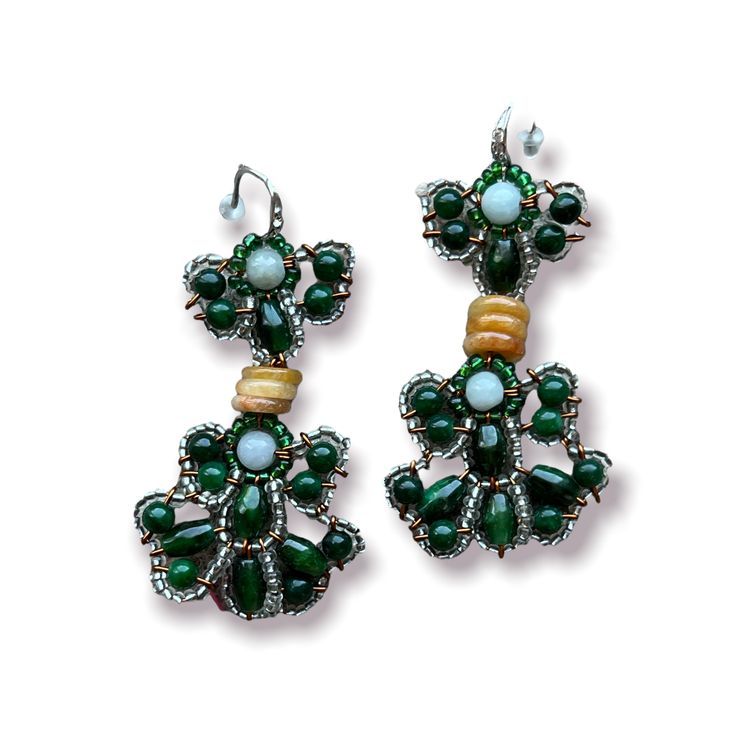 These green beauties of dangling jade earrings are made with dark green, amber and light green jade set off with seed beads to give it an iridescent look. Made by a husband and wife team that knows how to use jade in novel ways these earrings are stunners. Details: Dangling earrings with hook fastenings for pierced ears. Size: Length of drop: ~ 3" (7 cm), width: ~ 1" (2.5 cm) Material: Jade, seed beads Green Jade Earrings With Natural Stones, Green Onyx Drop Earrings, Green Onyx Jewelry With Matching Earrings, Elegant Jade Beaded Earrings, Handmade Bohemian Green Crystal Earrings, Bohemian Green Handmade Crystal Earrings, Green Malachite Bohemian Jewelry, Elegant Handmade Green Beaded Earrings, Jade Beaded Drop Earrings