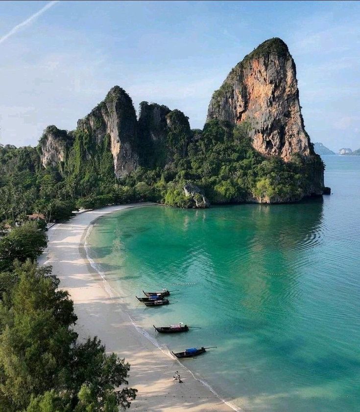 several boats are parked on the beach near an island