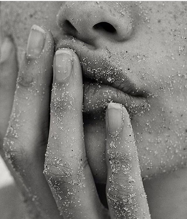 black and white photograph of a woman's face covered in sand