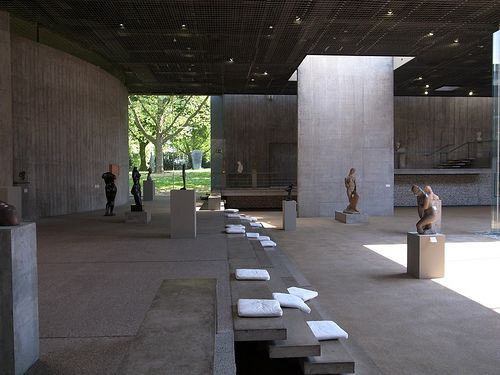 an open space with sculptures and benches in it