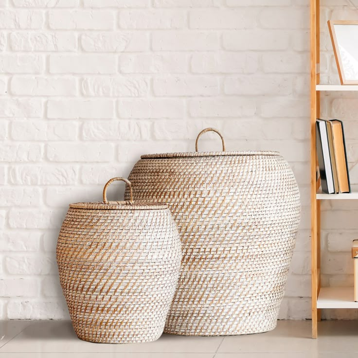 two large baskets sitting next to each other on a white tiled floor in front of a bookshelf