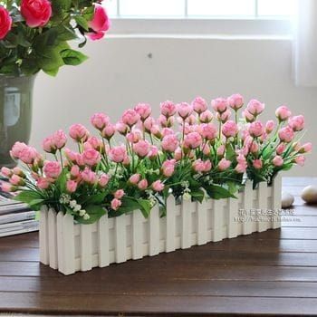 pink flowers are arranged in white vases on a table