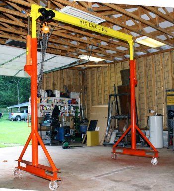 the inside of a garage with two lift stands in front of it and tools on the floor