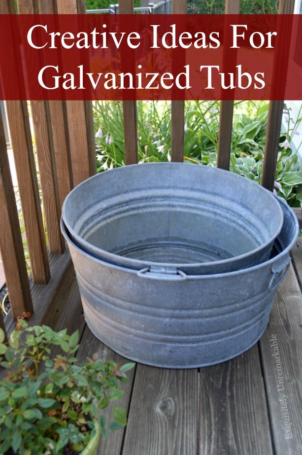 two galvanized tubs sitting on top of a wooden deck next to plants