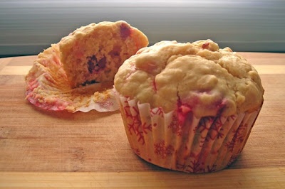 two muffins sitting on top of a wooden cutting board