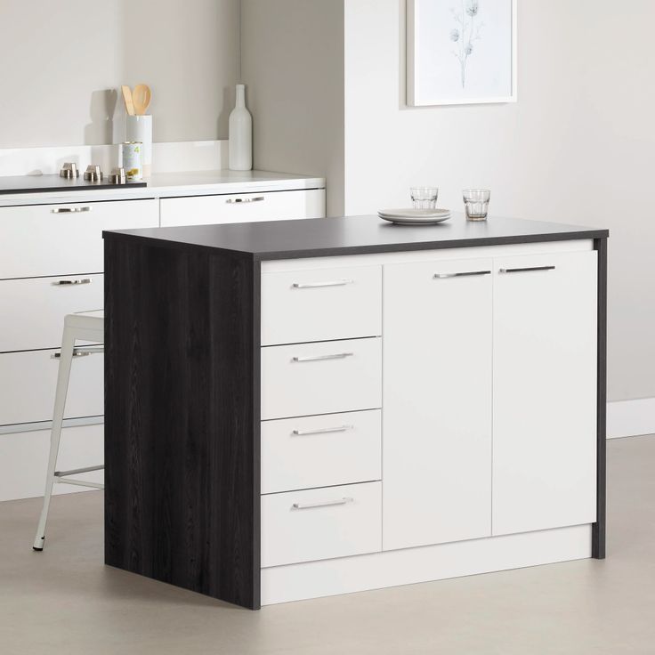 a kitchen with white cabinets and black counter tops in front of a painting on the wall