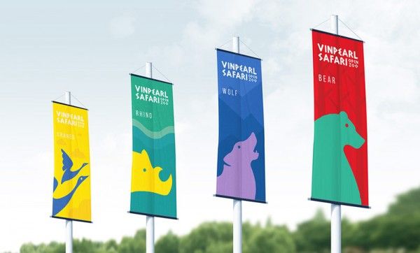 four colorful banners on poles with trees in the background